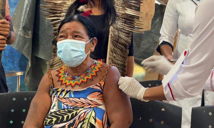 Senhora ndigéna recebendo a dose da vacina contra a covid-19